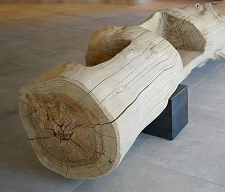 ... und der Baum wird Kunst | Das 5 Sterne Hotel Schenna Resort Quelle des Lichts sollte umgebaut werden. Auf dem ausgewählten Baugrund – einem Kinderspielplatz – stand eine mächtige Zeder. Die vielen Kindheitserinnerungen bewegten die Familie Pföstl-Wörndle dazu, dieses wertvolle Stück Natur in ihrem neuen Hotel miteinzubeziehen. Hansjörg war der Richtige für diese verantwortungsvolle Aufgabe: Er zauberte aus der Zeder eine Sitzgelegenheit und gleichzeitig ein Kunstwerk, das in der Eingangshalle des Hotels einen würdigen Platz bekommen hat. 